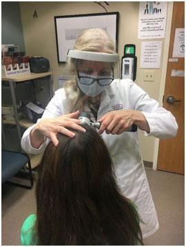 Dr. Pace using tricoscopy to examine a patient's scalp